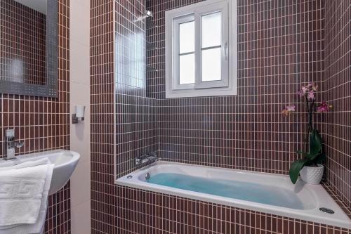 a bathroom with a tub and a sink and a window at Casa Las Minas in San José