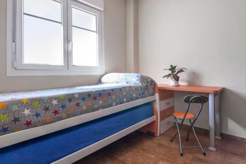 a bedroom with a bed and a desk and a window at Casa Las Minas in San José