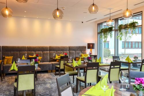 a restaurant with tables and chairs and a couch at Novotel Poznań Malta in Poznań