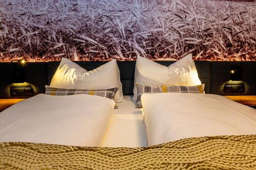 2 Betten mit weißer Bettwäsche und Kissen in einem Zimmer in der Unterkunft Hotel Hausschachen in Weitra