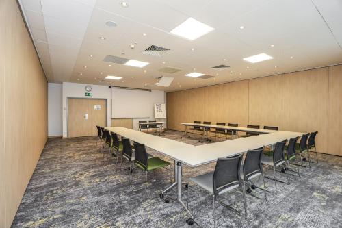 a conference room with a long table and chairs at Novotel Poznań Malta in Poznań