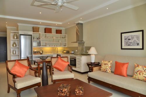 a kitchen and living room with a couch and a table at Eden Island Luxury Accommodation in Eden Island