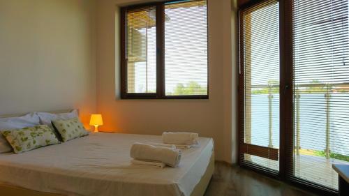 a bedroom with a bed with two towels on it at Вила Матилда - Villa Matilda in Bŭlgarevo