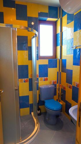 a bathroom with a blue toilet and a sink at Вила Матилда - Villa Matilda in Bŭlgarevo