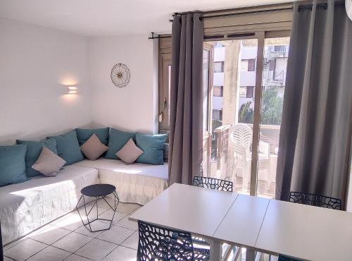 ein Wohnzimmer mit einem Sofa und einem Tisch in der Unterkunft Résidence Graziella Studio 306 in Juan-les-Pins