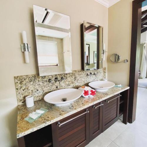 a bathroom with two sinks and a large mirror at Eden Island Luxury Accommodation in Eden Island