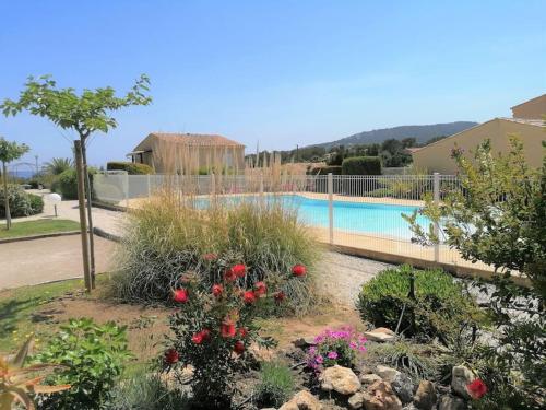 un jardin fleuri et une piscine dans l'établissement Le Farniente, maison 2pas piscine, 5mn à pied mer, à Saint-Aygulf