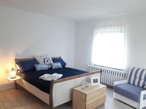 um quarto com uma cama e uma cadeira azul em Salzhaff 4 You em Teßmannsdorf