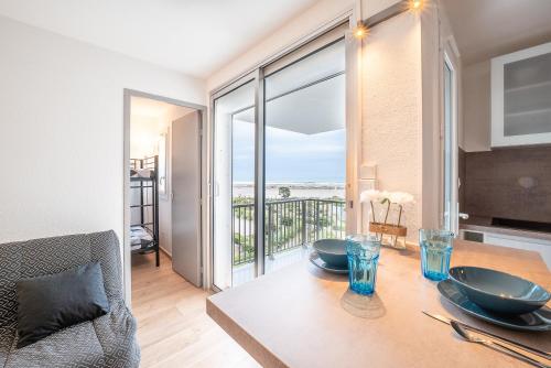 une salle à manger avec une table avec vue sur l'océan dans l'établissement Le Bleu Soleil - Bel appt pour 4 vue mer, au Barcarès