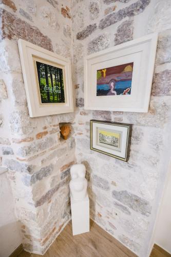 a room with stone walls and two pictures on the wall at Apartmani Art Karampana in Kotor