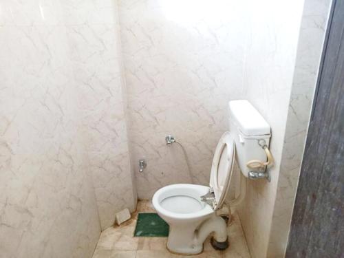 een badkamer met een wit toilet in een stal bij Goroomgo Kashi Inn Varanasi Near Railway Station in Varanasi