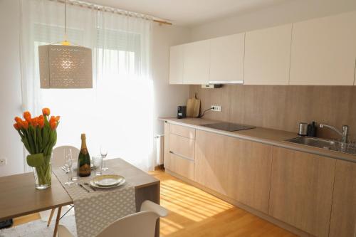 une cuisine avec des placards blancs, une table et une salle à manger dans l'établissement HIDDEN GEM Ljubljana, à Ljubljana