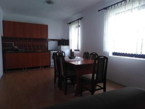 a dining room with a table and chairs and a kitchen at Smestaj Vlasina in Surdulica