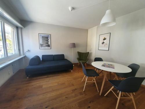 a living room with a blue couch and a table at Appartamento Fidanza 4 in Brissago Center in Brissago