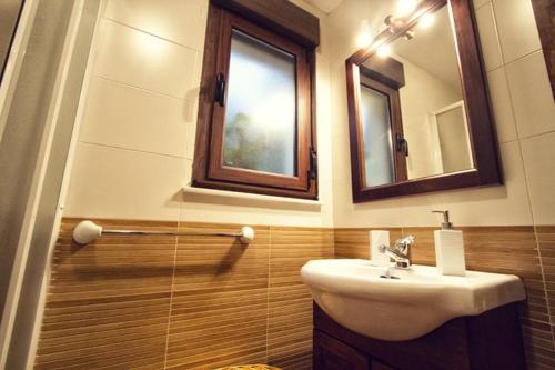 ein Badezimmer mit Waschbecken und Spiegel in der Unterkunft Apartamentos el Caserón in Soto de Cangas