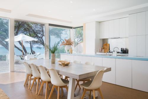 a kitchen with a wooden table and chairs at The Cove Beach Front Luxury House in Port Fairy