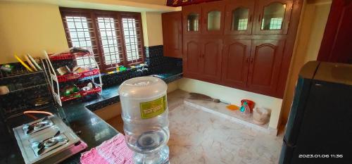 a kitchen with a counter with a water bottle on the floor at PALAZHI in Kovalam