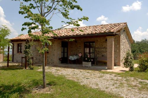 a small stone house with a man standing in the doorway at B&B Al Felcino in Fabro