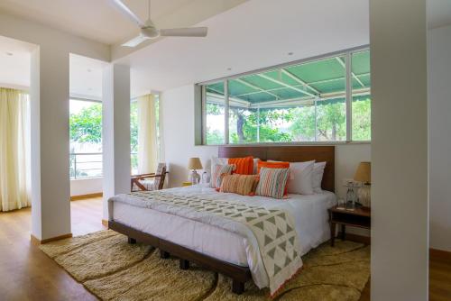 ein Schlafzimmer mit einem großen Bett mit einem großen Fenster in der Unterkunft ama Stays & Trails White House, Lonavala in Lonavla
