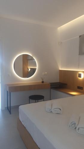 a bedroom with a white bed and a mirror at Marigold Apartments in Chania Town