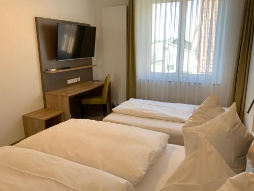 a hotel room with two beds and a television at Gasthaus Sonne in Hohenstadt