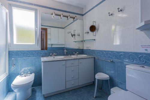 łazienka z 2 umywalkami, toaletą i oknem w obiekcie Villa S'illot 105 By MENORCARENTALS w Son Bou