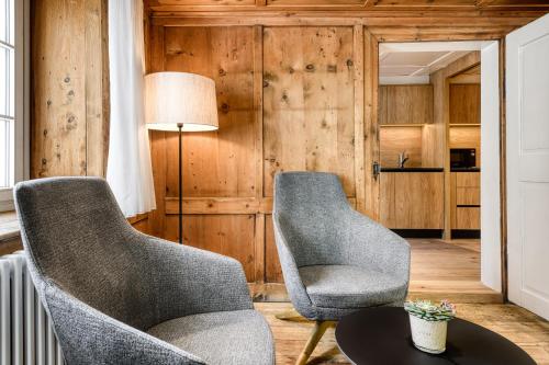 two chairs and a table in a room with wooden walls at Münsterhus by A-Appartments in Schruns-Tschagguns