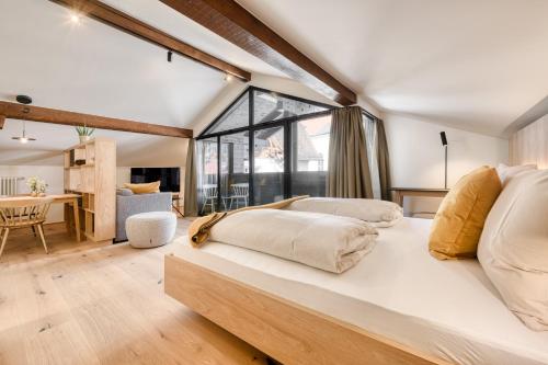 duże łóżko w pokoju z dużym oknem w obiekcie Münsterhus by A-Appartments w mieście Schruns