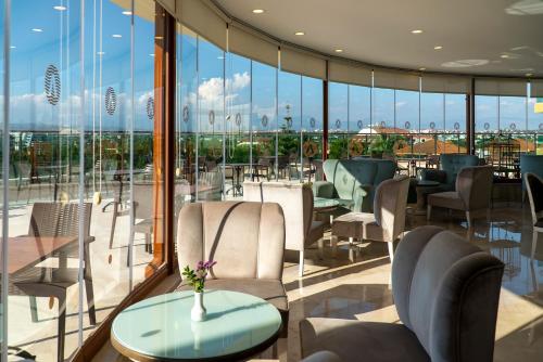 a restaurant with chairs and tables and glass windows at Adalya Art Side - Ultra All Inclusive in Side