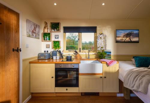 a kitchen with a sink and a counter top at Hillside View Shepherds Hut - Ockeridge Rural Retreats in Little Witley