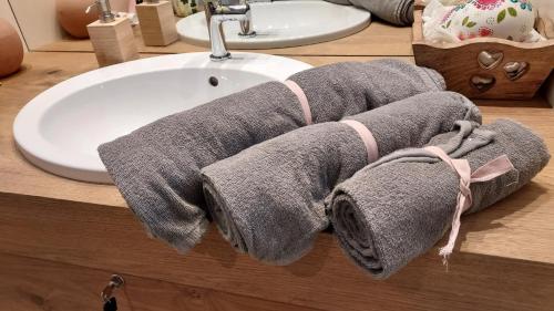 - une serviette sur un comptoir de salle de bains à côté d'un lavabo dans l'établissement Relax Home Fie' allo Sciliar - Alpe di Siusi Val Gardena, à Fiè