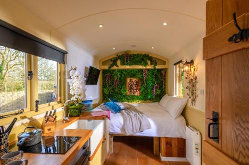 um pequeno quarto com uma cama num quarto em Hillside View Shepherds Hut - Ockeridge Rural Retreats em Little Witley