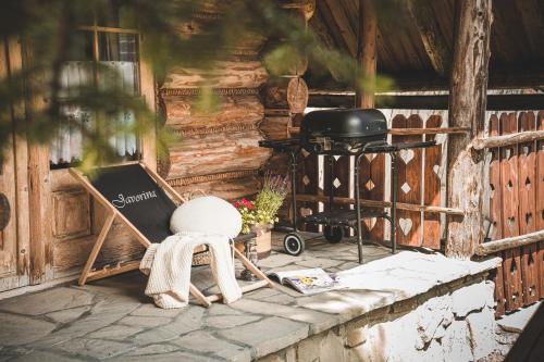 een stoel op een veranda naast een grill bij Domki Javorina in Zakopane