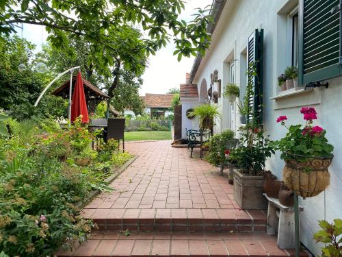 a brick walkway with flowers and plants next to a house at Bed & Breakfast Chez Lips in Oberbildein