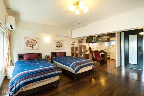 a bedroom with two beds and a dining room at Nanei Building - Vacation STAY 04905v in Kagoshima