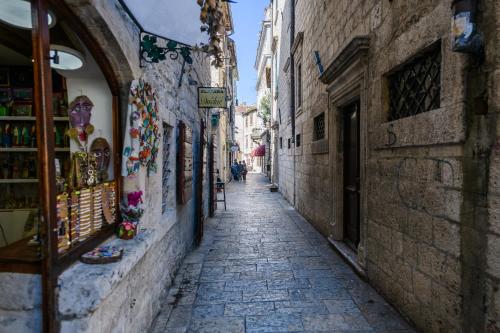 an alley in an old town with people walking down it at Apartmani Art Karampana in Kotor