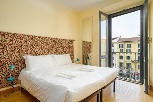 a bedroom with a large bed and a large window at Brera - San Marco Cozy Apartment in Milan