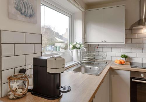 a small kitchen with a sink and a microwave at Ty Golau in Llanbedrog