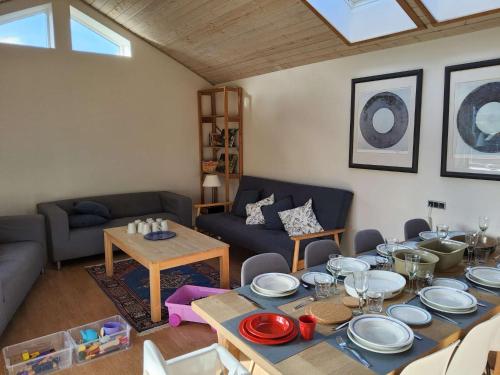 a living room with a table with plates on it at Family Friendly Apt A, Garden, 900m LegoHouse, Lalandia, Legoland in Billund