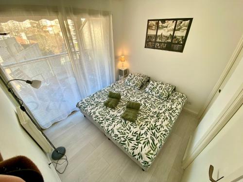 une petite chambre avec un canapé en face d'une fenêtre dans l'établissement Le Magnolia By SCLS Locations, à Cannes