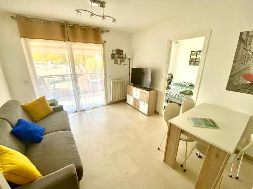 un salon avec un canapé et une table dans l'établissement Le Magnolia By SCLS Locations, à Cannes