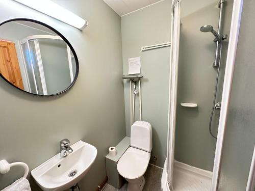 a bathroom with a toilet and a sink and a mirror at Cave Cabins in Hella