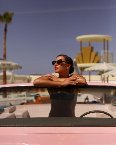 a woman in sunglasses leaning on a table at the beach at Grand Paradiso Ibiza - Adults Only in San Antonio Bay