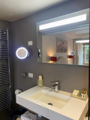 Un baño con un lavabo blanco y un espejo. en Casa L'Andrunèl, en Limone sul Garda