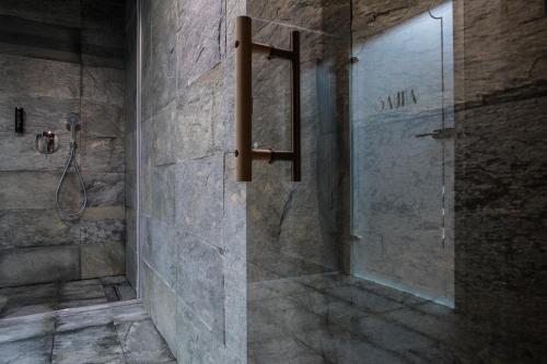 a bathroom with a shower with a glass door at INX Design Hotel in Kraków