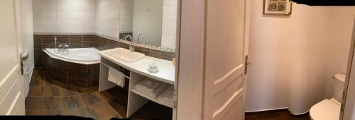 La salle de bains est pourvue d'un lavabo, de toilettes et d'une baignoire. dans l'établissement Chambres d'hôtes Le Relais de la Perle, à Le Vernois