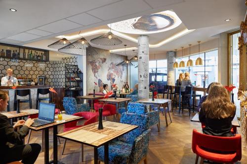 een restaurant met mensen aan tafels en stoelen bij INX Design Hotel in Krakau