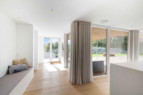 uma sala de estar com paredes brancas e janelas do chão ao tecto em Heavenport em Vester Sømarken