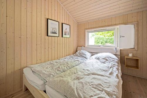 1 dormitorio con 1 cama en una habitación con ventana en Dronningmlle en Dronningmølle