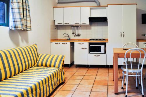 a kitchen with a couch and a table in a kitchen at Residence Le Mimose in Procchio
